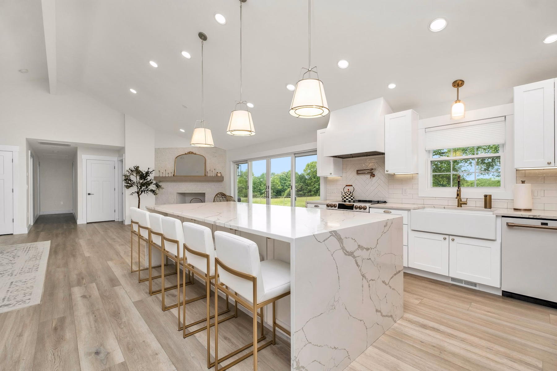 Bright open-plan kitchen with a long island, white cabinets and a wood-look floor