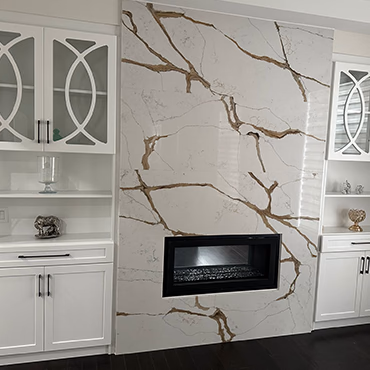 Feature wall of veined stone around a linear fireplace and mounted television