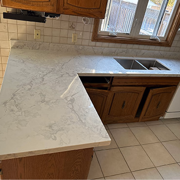 Kitchen peninsula with a quartz waterfall edge
