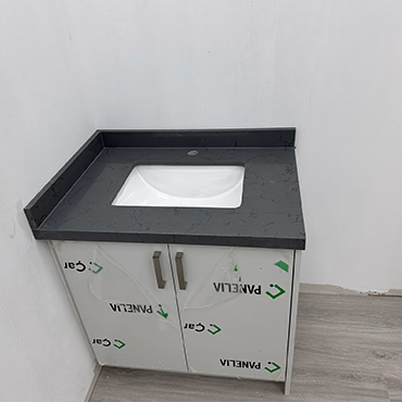 Dark stone vanity top with a white undermount sink on a white vanity